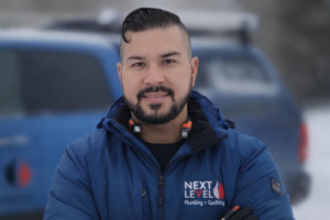 Professional plumbing and gas fitting technician standing outdoors in winter wearing a branded jacket