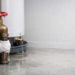 Emergency plumbing repair with leaking pipe and water pooling on the floor in Whitehorse and Teslin Yukon